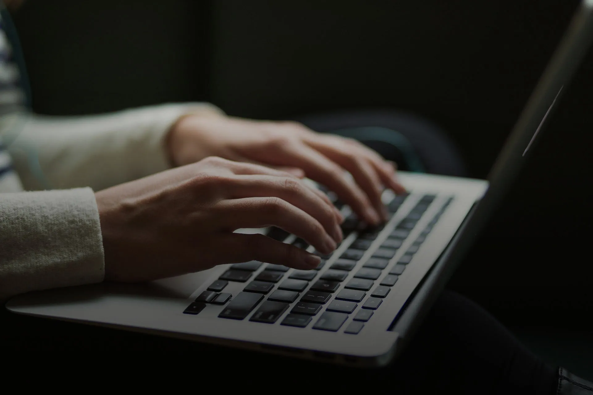 A person is typing on a laptop. Only the hands and the keyboard of the laptop is in the frame.