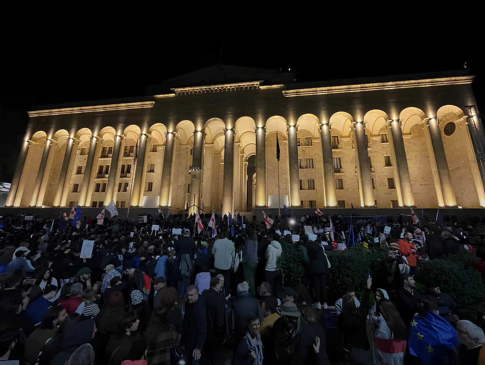 Big crowd of protesters standing in front of Parliament in Tbilisi.